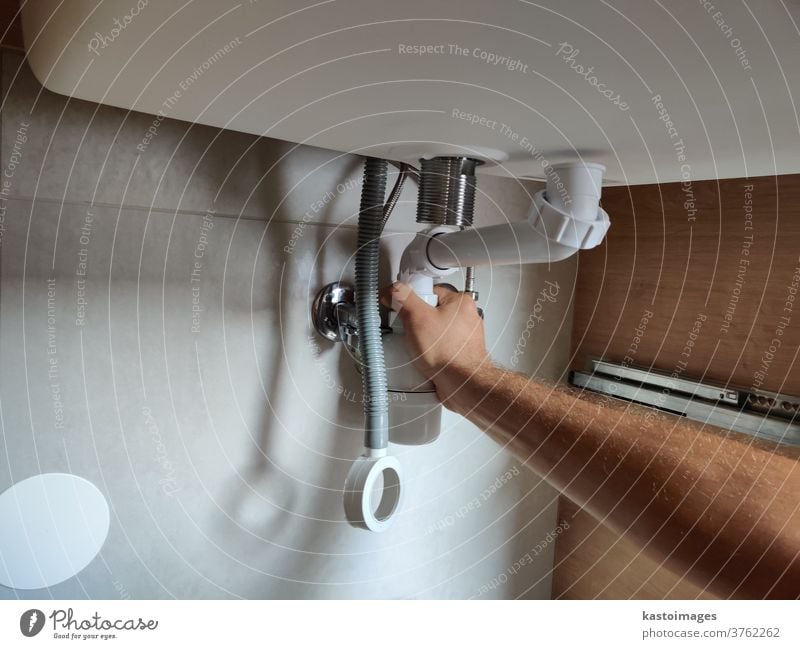 Klempner baut einen Siphon unter dem Waschbecken des Badezimmers ein Zusammenbau siphonieren unten Badezimmer-Waschbecken Tube Ventil Wasserhahn Innenaufnahme