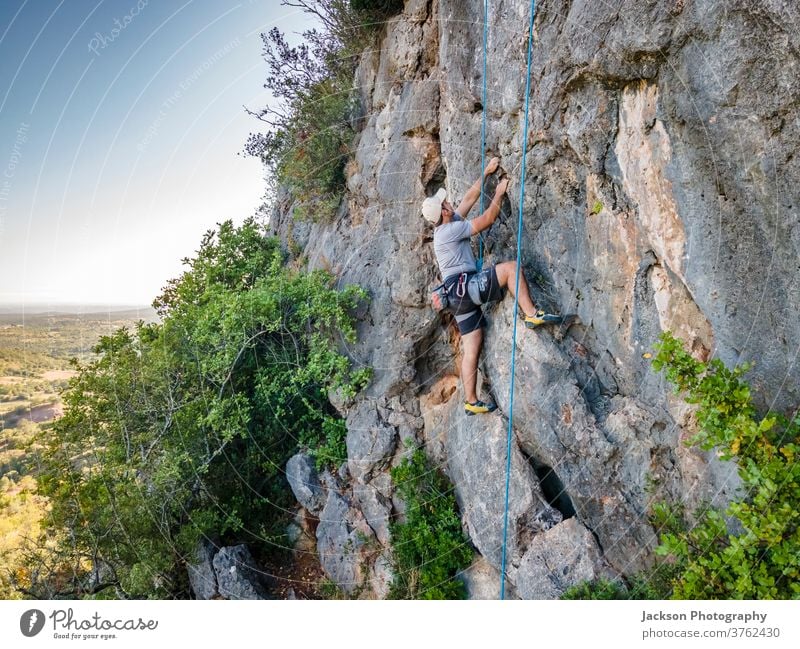 Bergsteiger mit Klettergurt auf riesigem Felsen Sport Aufsteiger Klettern Mann aktiv Aktivität Adrenalin Abenteuer Algarve Mut Karabiner Herausforderung Klippe