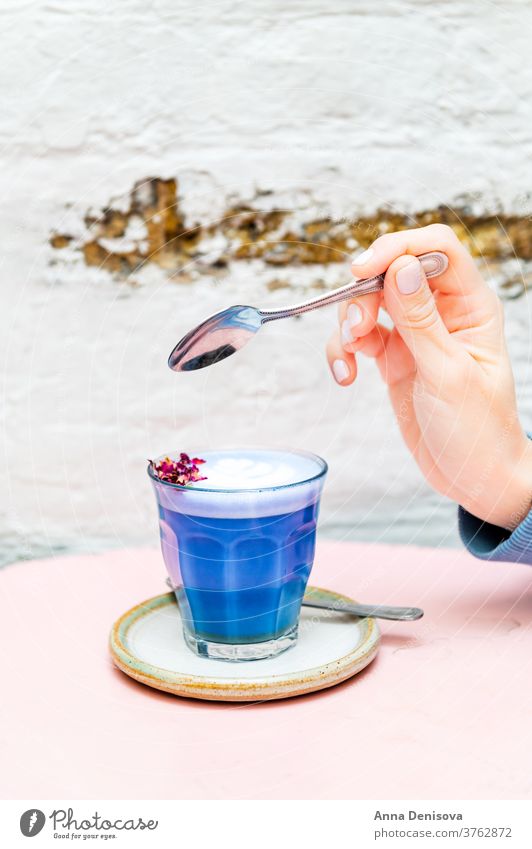 Schmetterling Matcha aus organischem blauen Matcha Latte Kunst trinken Gesundheit Getränk Kaffee Hand Frau Löffel süß Erfrischung Tisch heiß Café Ernährung