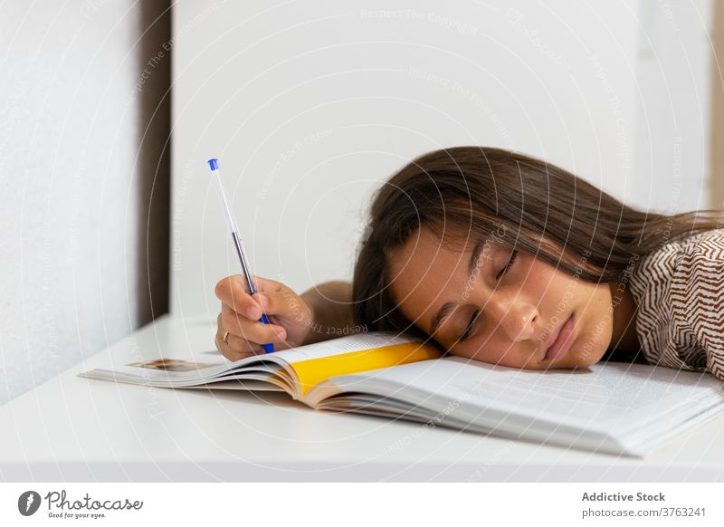 Müder Schüler schläft am Tisch schlafen müde Frau erschöpft vorbereiten Prüfung Lehrbuch Überarbeitung Bildung lernen jung Buch Wissen schlafend Müdigkeit