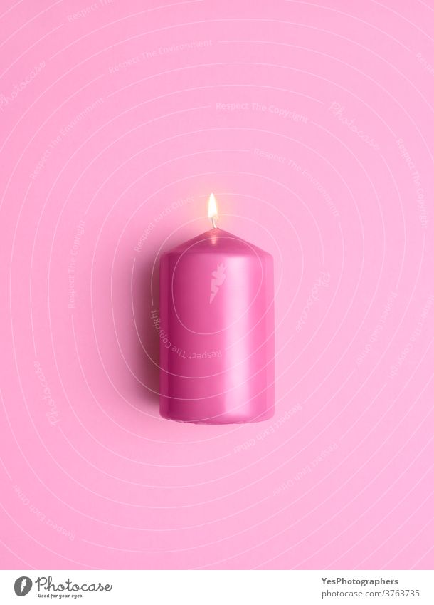 Beleuchtete Kerze isoliert auf rosa Hintergrund. Aromatisch rosa brennende Kerze Jahrestag aromatisch hell Brandwunde Kerzenschein Feier Festakt Weihnachten