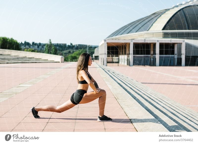 Fit Frau Stretching Beine auf der Straße Training Übung Ausfallschritt Dehnung urban Athlet passen Sportlerin jung schlank Fitness Sportbekleidung Aufwärmen