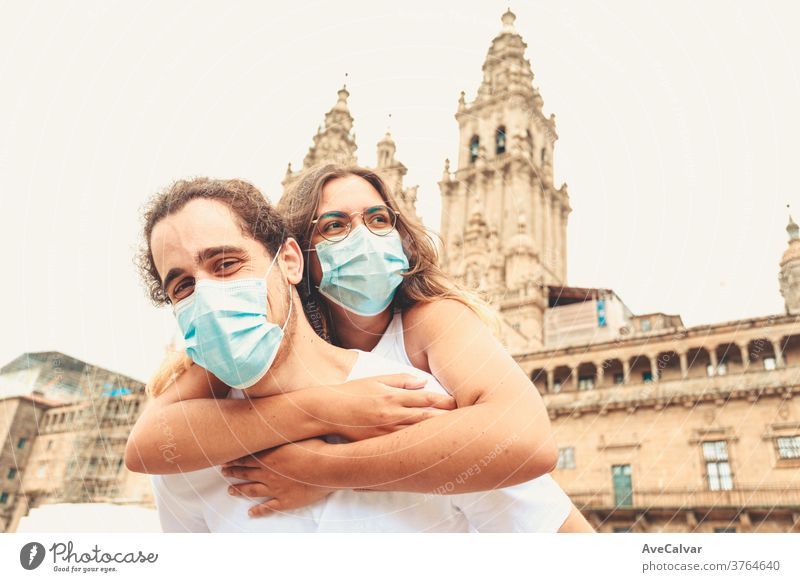 Junges Paar amüsiert sich auf Reisen und lässt sich die Masken aufsetzen Erwachsener berührend Pandemie multikulturell Verantwortung Frau jung Emotion