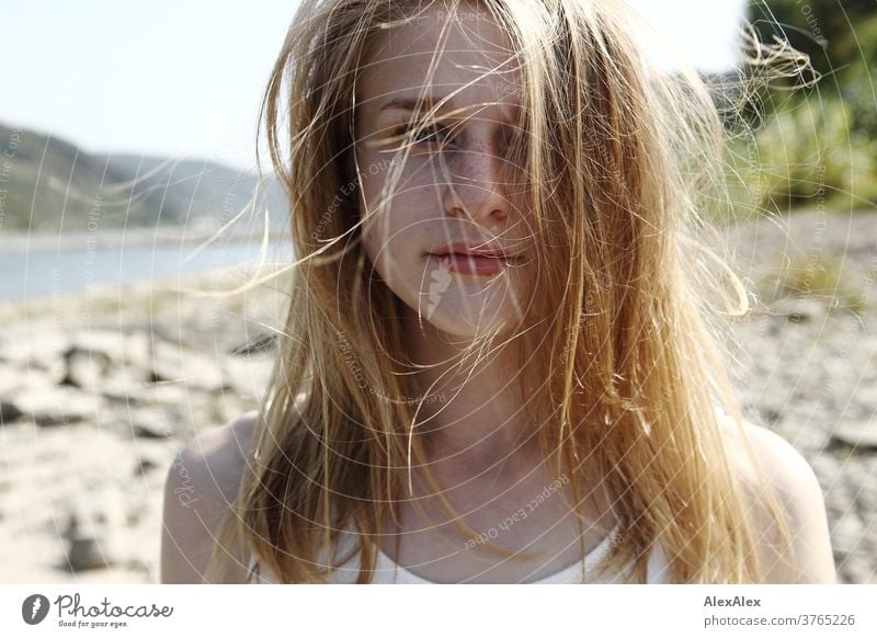 Nahes Gegenlicht- Portrait einer jungen, sommersprossigen Frau mit vom Winde verwehten Haaren am Rheinufer junge Frau schlank schön athletisch blond 18-25 Jahre