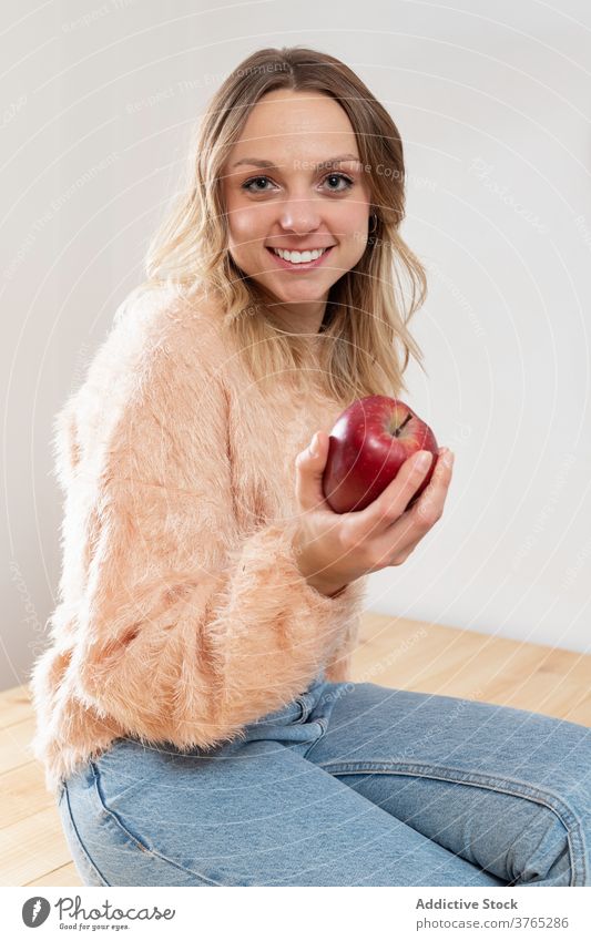 Fröhliche Frau mit Apfel in der Küche frisch gesunde Ernährung lecker Freude Vitamin Frucht heimwärts Tisch Glück Lebensmittel Diät organisch heimisch Vergnügen
