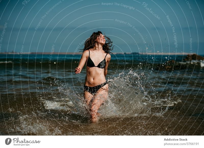 Sorglose Frau läuft im Meerwasser laufen MEER Spaß haben platschen Wasser Sommer Urlaub Feiertag Bikini seicht Resort sich[Akk] entspannen sorgenfrei Glück