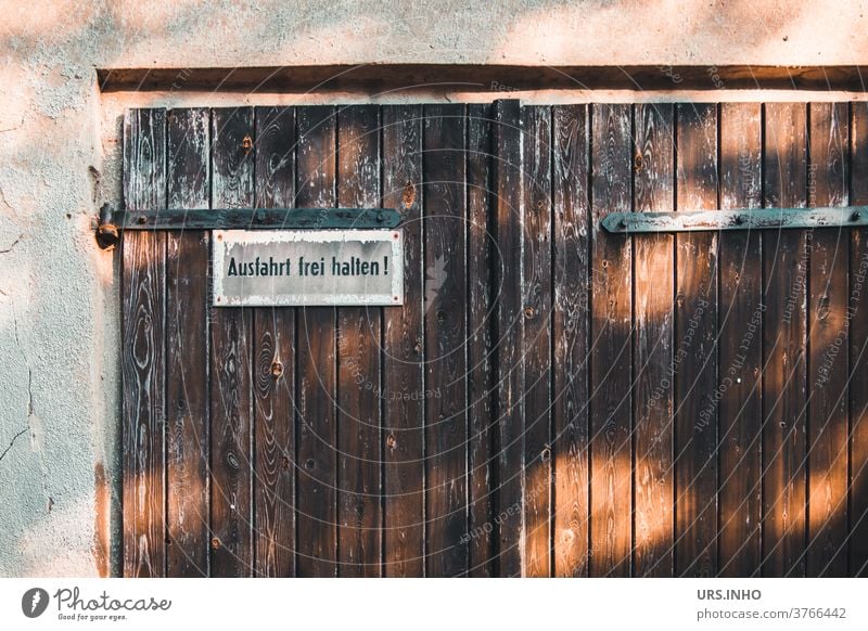 vor dem alten Garagentor soll nicht geparkt werden Tor vintage Tür Doppeltür Schild Einfahrt Tag Ausfahrt freihalten parken verboten Warnschild Hinweisschild