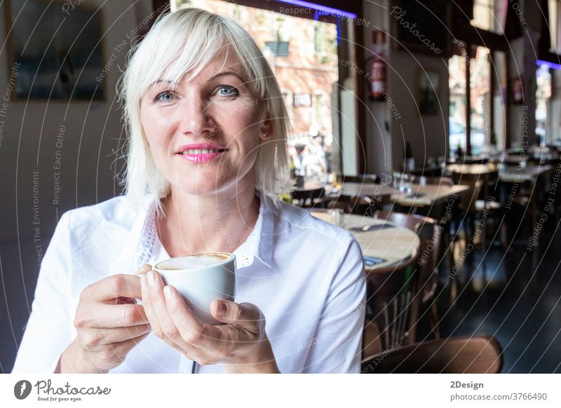 Junge blonde Frau trinkt Kaffee im Café Person Sitzen Tasse Lifestyle Tisch Lächeln Business Mädchen jung im Innenbereich Glück Erwachsener schön trinken