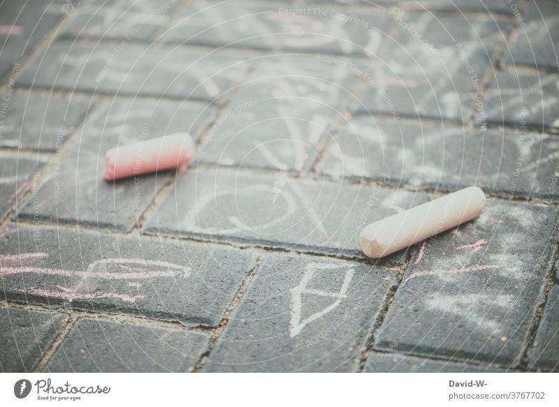 Kinder haben mit Kreide auf dem Boden gespielt malen Kindheit kinderbeschäftigung spass Kunst Kreativität draußen Zeichung Strassenmalerei