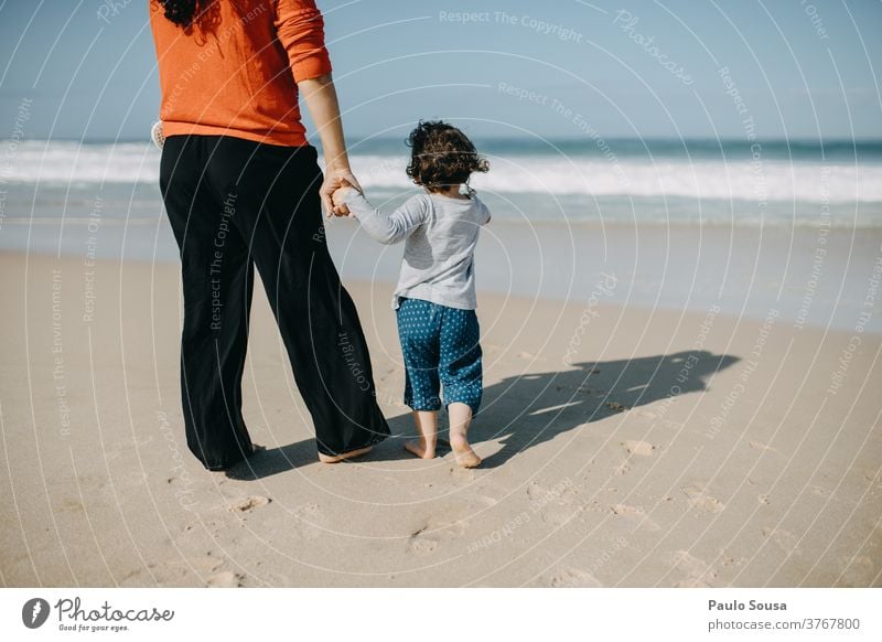 Mutter und Tochter schauen aufs Meer Mutterschaft Kind Strand Sandstrand reisen Tourismus Lächeln Kaukasier Kindheit Fröhlichkeit schön Eltern