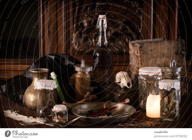 unheimliche Hexenküche mit vielen ekligen Zutaten für einen Zaubertrunk, Einmachgläsern und altertümlichen Geräten dunkel mit Kerzenschein beleuchtet für Halloween