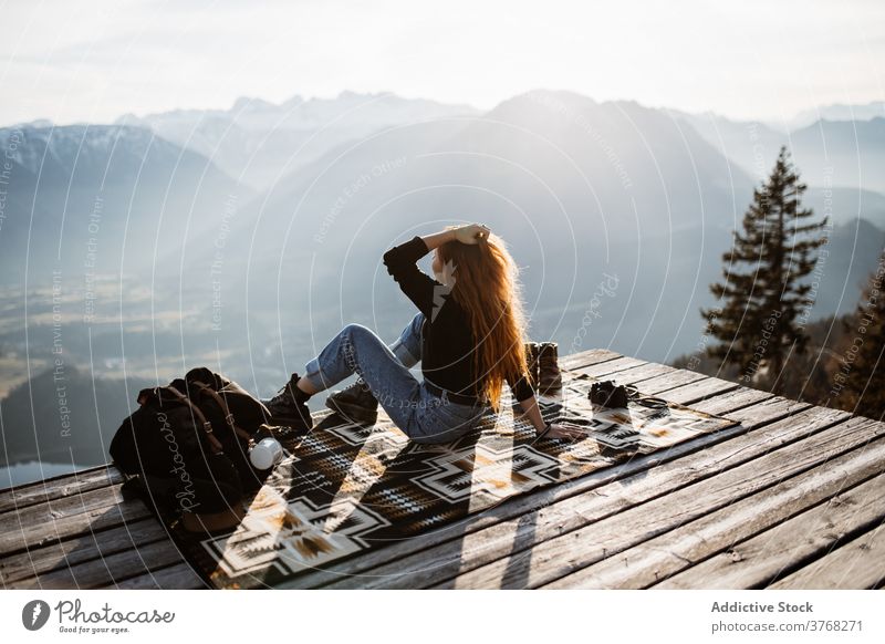 Reisende Frau auf Holzterrasse im Hochland Aussichtspunkt Berge u. Gebirge Morgen Reisender Nebel Sonnenstrahlen ruhig genießen Deutschland Österreich Tourist