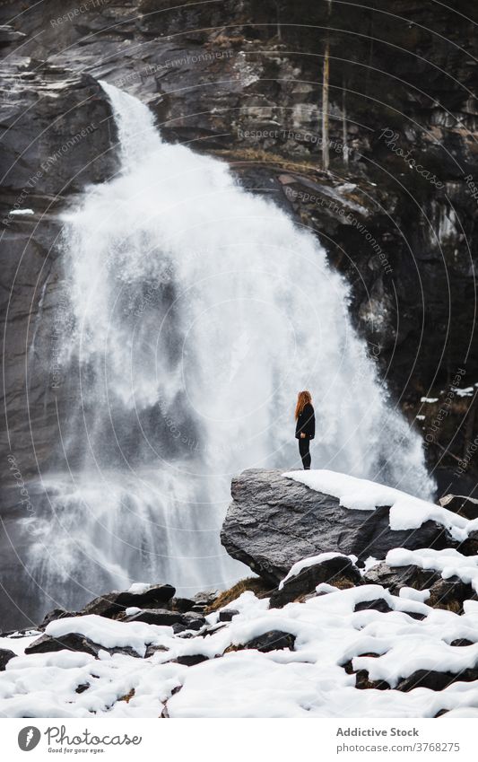 Weibliche Wanderer in der Nähe von Wasserfall im Winter Frau reisen beobachten bewundern strömen Kraft Deutschland Österreich erstaunlich Felsen