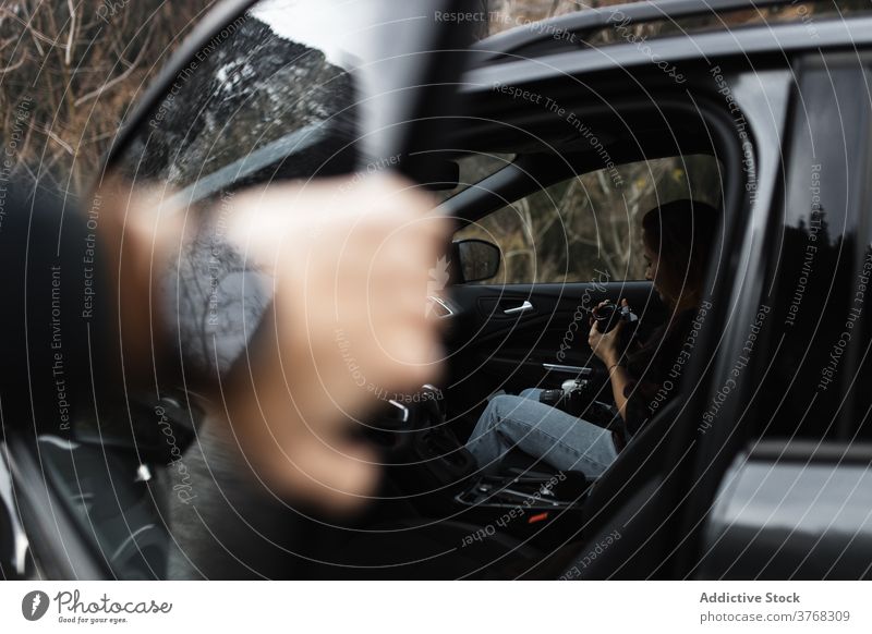 Reisende Frau mit Fotokamera im Auto sitzend Autoreise PKW Reisender Fotoapparat Waldgebiet Herbst Fotografie im Inneren reisen Lifestyle Fahrzeug Fernweh