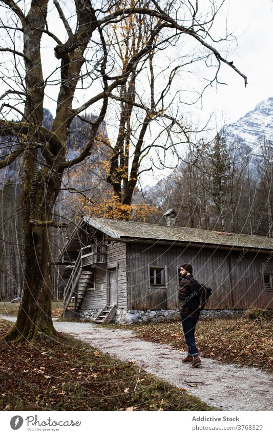 Reisende zu Fuß in der Nähe von alten Holzhaus im Herbst Wald Mann Wälder Haus Berge u. Gebirge Gebäude hölzern verwittert Reisender gealtert Kabine Landschaft