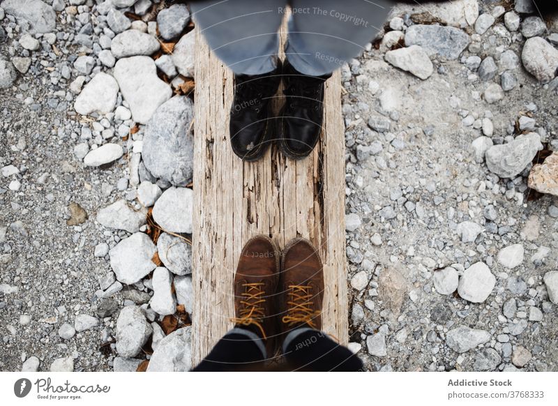 Paar Wanderer stehen auf Holzstamm Reisender Totholz Bein Stiefel Zusammensein Stein Natur verwittert hölzern reisen schäbig Abenteuer Nutzholz Tourismus