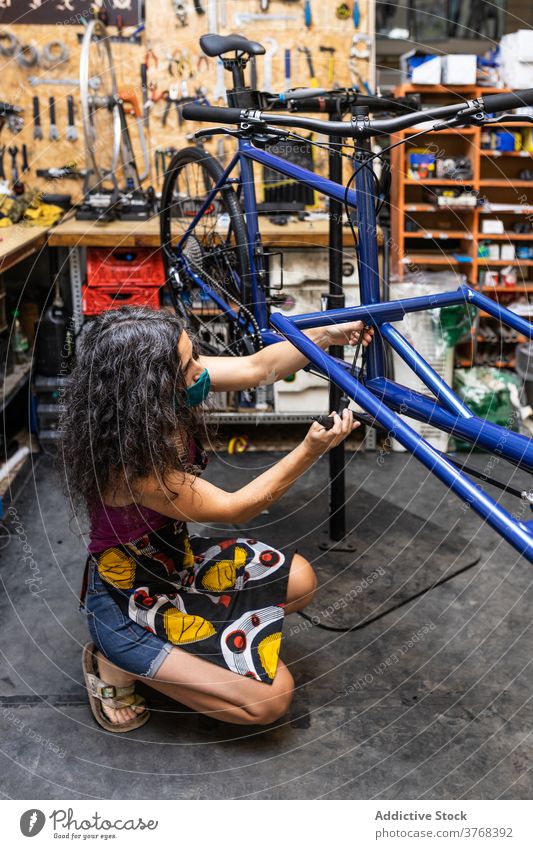 Frau repariert Fahrrad in der Werkstatt Reparatur Mechaniker fixieren Flugzeugwartung Dienst installieren Bremse Draht Beruf ethnisch professionell Arbeit Job