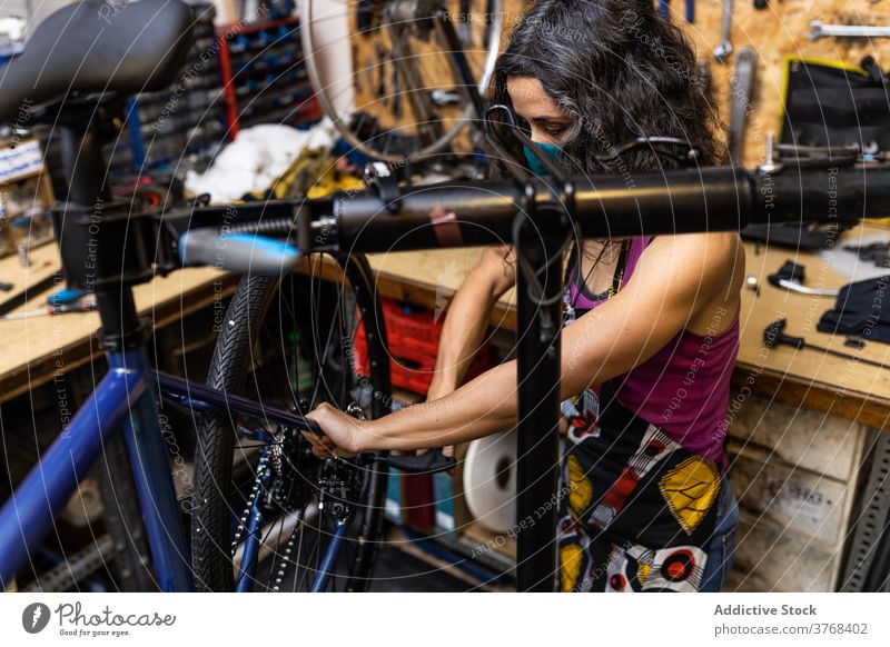Frau repariert Fahrradrad in der Werkstatt Reparatur Mechaniker Rad Speiche fixieren Flugzeugwartung Beruf Dienst professionell Arbeit Job Wehen beschäftigt