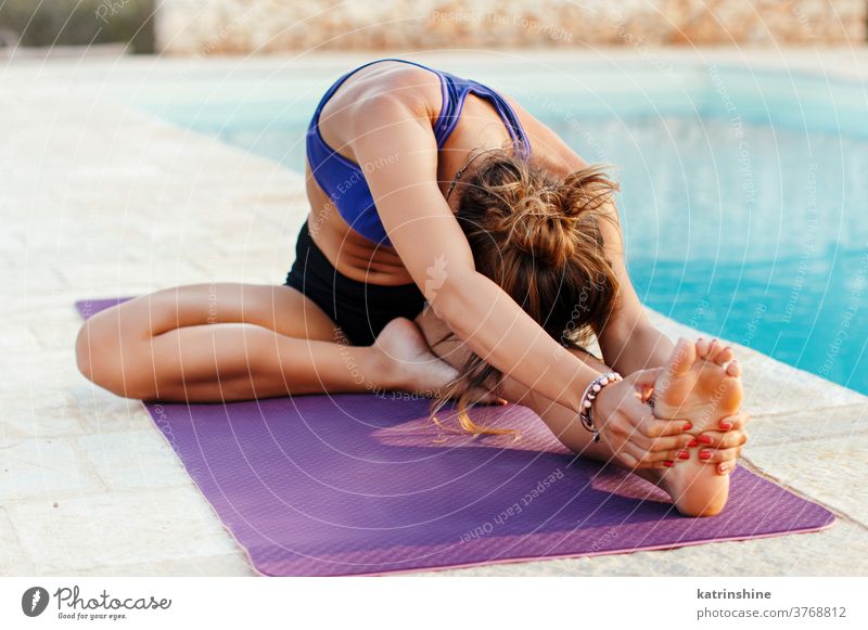 Junge Frau übt Dehnübungen in Kopf-Knie-Position jung praktizieren Yoga Pool Pose strecken Von Kopf bis Knie Konzentration Erholung Garten Gesundheit