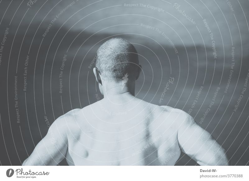 muskulöser Mann zeigt Rücken Schultern und Nacken Muskeln männlich sportlich Rückenmuskulatur Muskulatur Körper Kraft Fitness Mensch stark