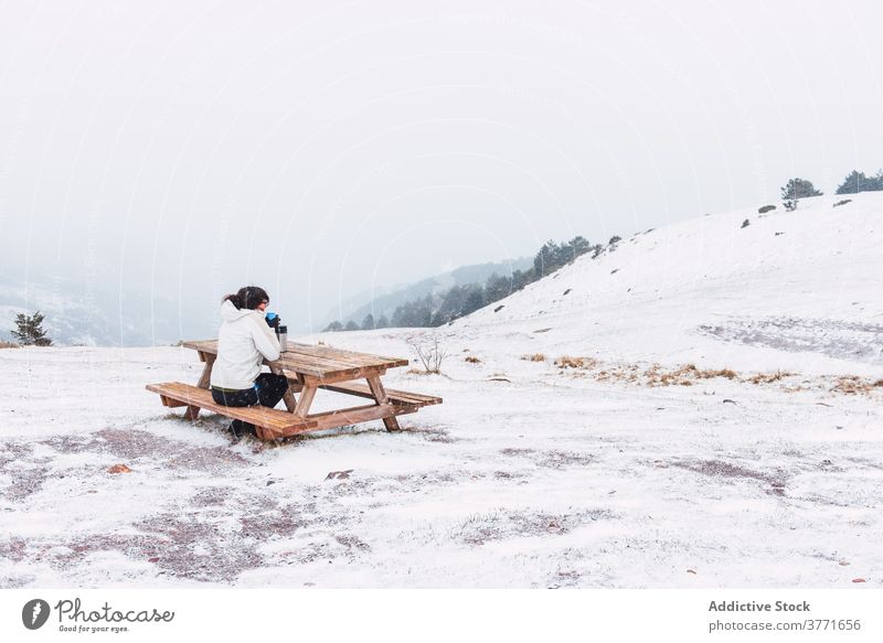 Unkenntlich Tourist sitzt auf Bank in den Bergen im Winter Berge u. Gebirge Reisender heiß Tee genießen Schnee Landschaft Tourismus erstaunlich Pyrenäen