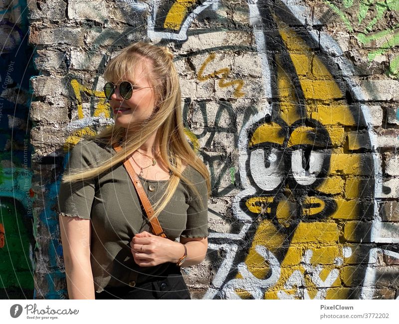 Junge Frau vor einem Graffitti Porträt feminin Erwachsene Mensch Außenaufnahme Gesicht lange Haare