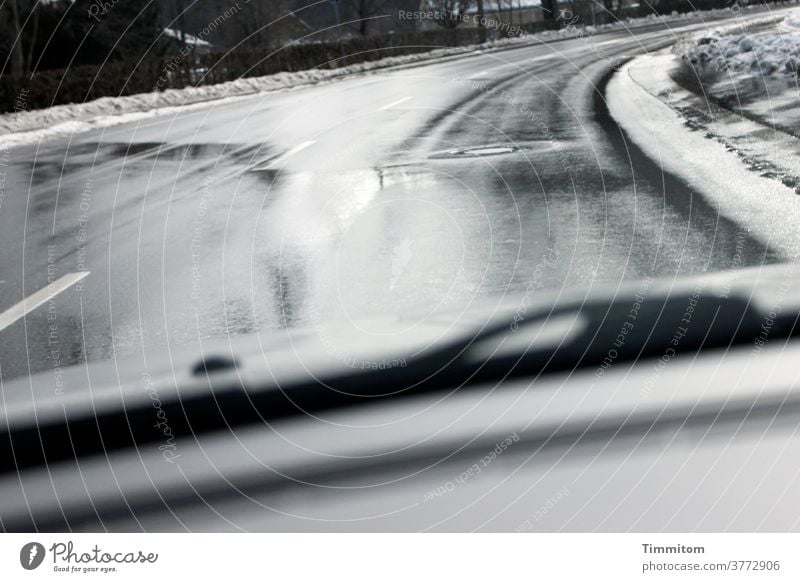 Es könnte zu Straßenglätte kommen Auto Autofahren Windschutzscheibe nass Schnee kalt Kurve Scheibenwischer Geschwindigkeit PKW Winter Verkehr Straßenverkehr