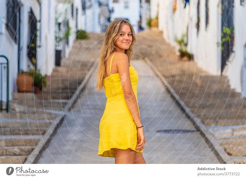 Lächelnde Frau im gelben Kleid in der Stadt charmant Sommer Großstadt Straße genießen urban Kultur reisen Tourismus Tourist Reisender Feiertag Urlaub jung Stil
