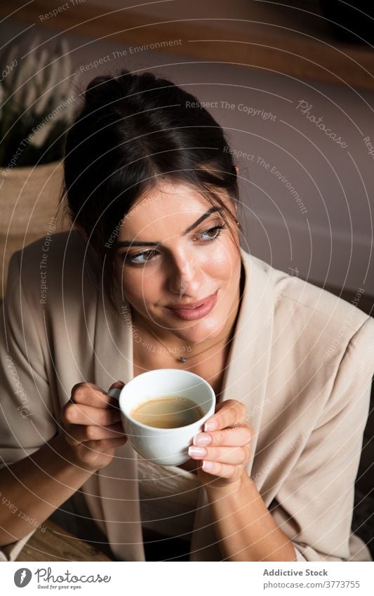 Ruhige Frau genießt heißen Kaffee zu Hause trinken sich[Akk] entspannen träumen heimwärts ruhen Tasse positiv Pause jung Getränk Lifestyle genießen Komfort