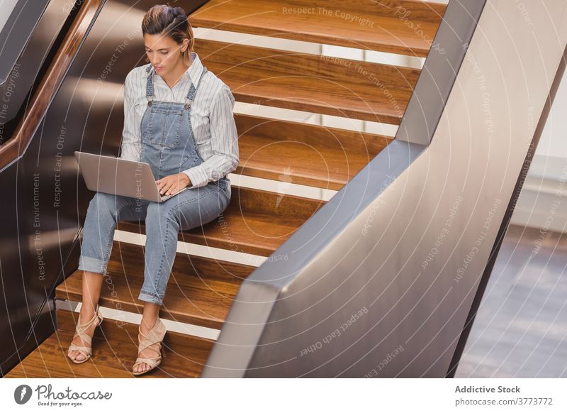Frau sitzt auf der Treppe und arbeitet am Laptop Arbeit freiberuflich Gebäude Projekt modern Treppenhaus Unternehmer benutzend Job Zeitgenosse Business sitzen