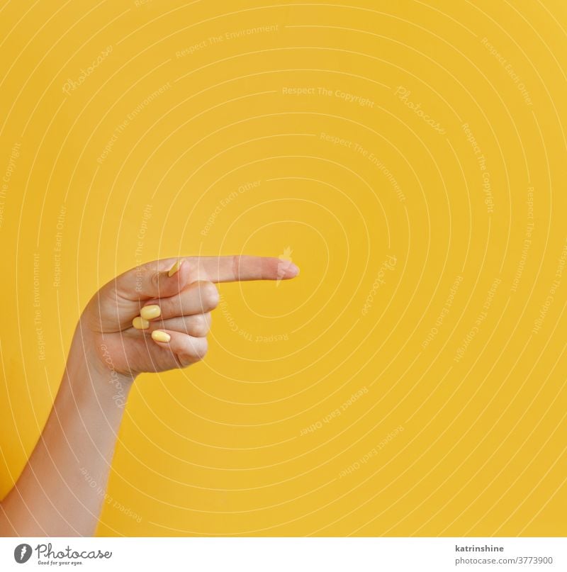 Nahaufnahme einer wegzeigenden weiblichen Hand auf gelbem Hintergrund Punkt Monochrom hell Frau gesichtslos Konzept Textfreiraum Negativraum gestikulieren Arme