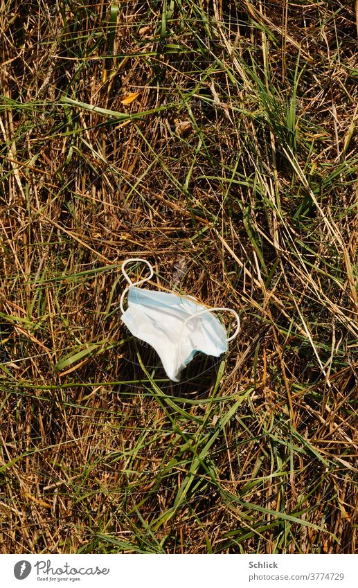 Coronakrise Atemschutzmaske achtlos weggeworfen liegt sie im Gras coronavirus wegwerfen Natur Plastik Kunststoff Textil synthetics Umwelt Umweltbelastung
