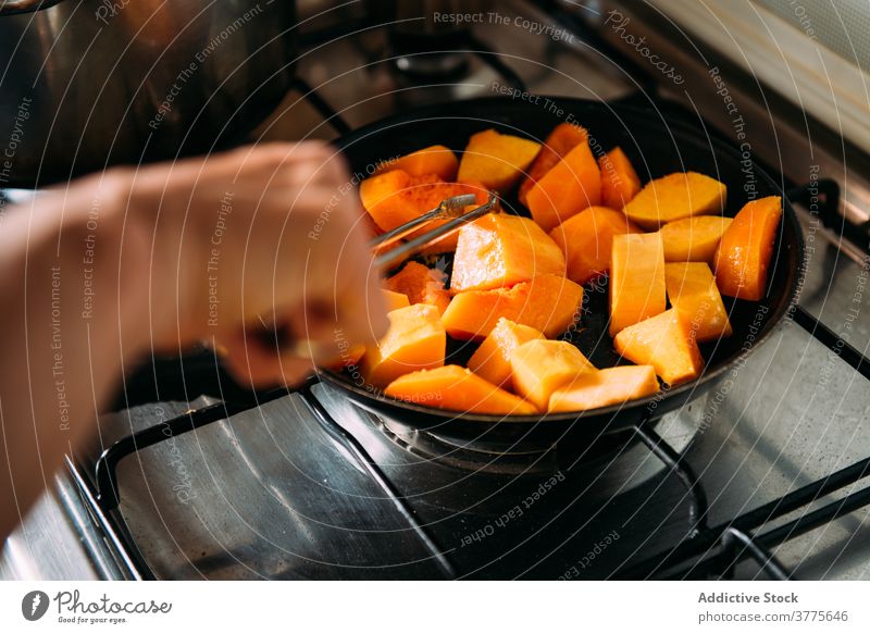 Hausfrau bereitet Kürbis für Suppe vor Koch vorbereiten schmoren Gemüse Bestandteil Lebensmittel Küche hinzufügen Frau Rezept kulinarisch selbstgemacht