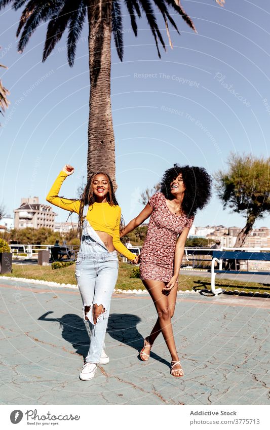 Lächelnd schwarze Frauen zu Fuß entlang Straße zusammen Freund Spaziergang tropisch Zusammensein Freude Freundschaft bester Freund Sommer ethnisch
