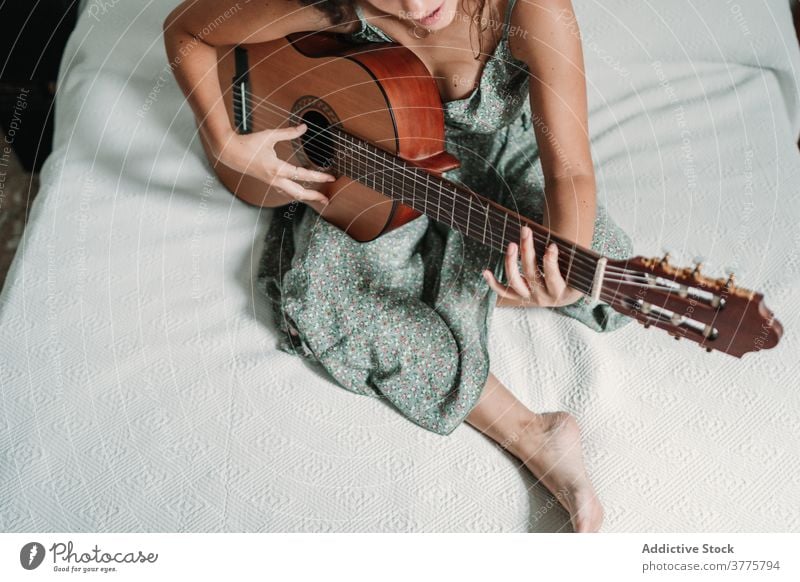 Frau spielt Gitarre im Schlafzimmer Gitarrenspieler Musik spielen heiter Lachen Talent unterhalten sorgenfrei Instrument ethnisch akustisch gemütlich Bett