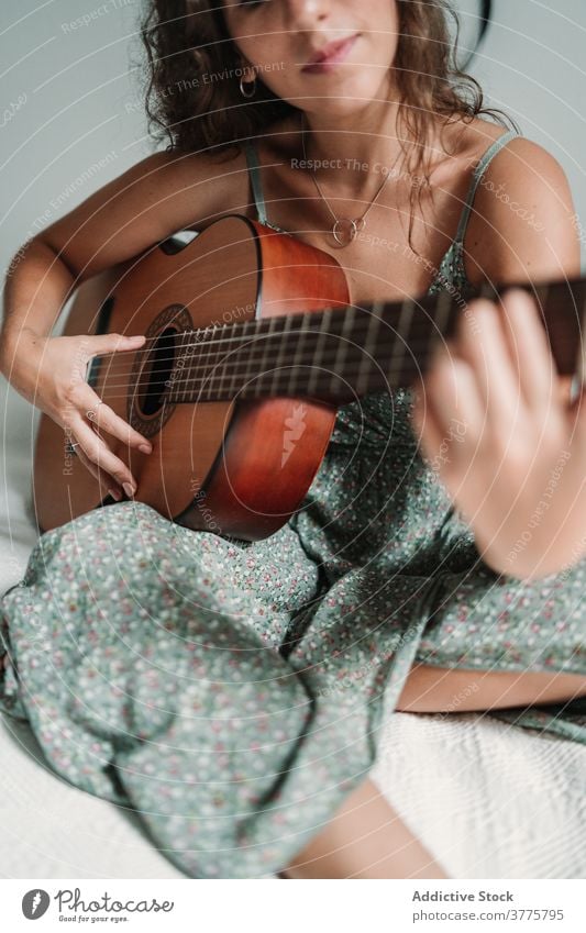 Positive Frau spielt Gitarre im Schlafzimmer Gitarrenspieler Musik spielen heiter Lachen Talent unterhalten sorgenfrei Instrument ethnisch akustisch gemütlich