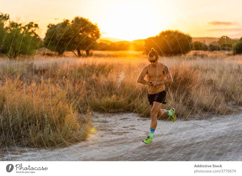 Energetischer Mann läuft auf sandiger Straße Läufer Armbanduhr laufen prüfen Sportler Athlet Herz sich[Akk] bewegen männlich ländlich Sand stark Körper Fitness