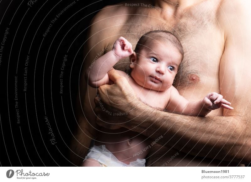 Junger Vater hält ein Neugeborenes mit Windel vor dem Körper neugeboren Gesicht Baby Sohn Beteiligung umarmt Umarmung bezaubernd abstützen schön Pflege heiter
