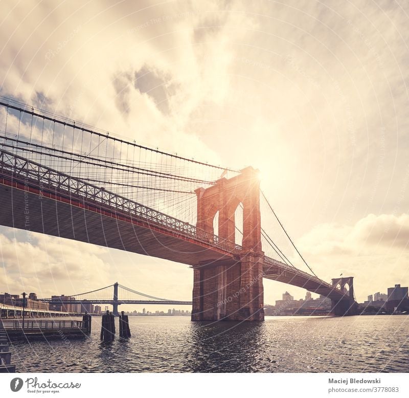 Vintage getöntes Bild der Brooklyn Bridge gegen die Sonne, New York. New York State Großstadt retro altehrwürdig Gebäude Stadtbild Sonnenuntergang Fluss Skyline