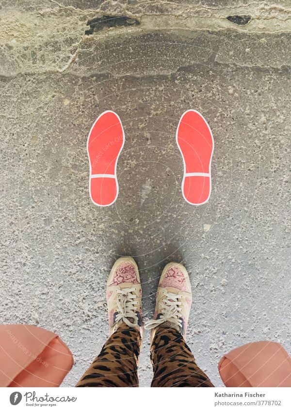 Schritte auf der Strasse in rot Vogelperspektive Schuhe Außenaufnahme Tag Fuß Beine Hose Farbfoto Bodenbelag Sneaker Fußabdruck; stehen Straße braun grau Stein