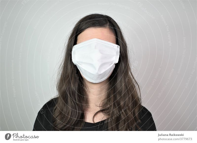 Frau mit Atemschutzmaske im Gesicht Kein Gesicht Mensch Maske Porträt Schutz atmen Kopf bedrohlich gefährlich coronavirus Angst Krankheit Infektionsgefahr