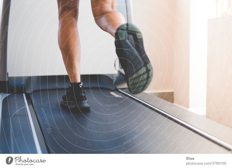 Ein Mann läuft im Fitnessstudio auf einem Laufband. Detailaufnahme der Beine in Bewegung. laufen joggen Sport Training sportlich Fitnesstudio Männerbeine Aktion