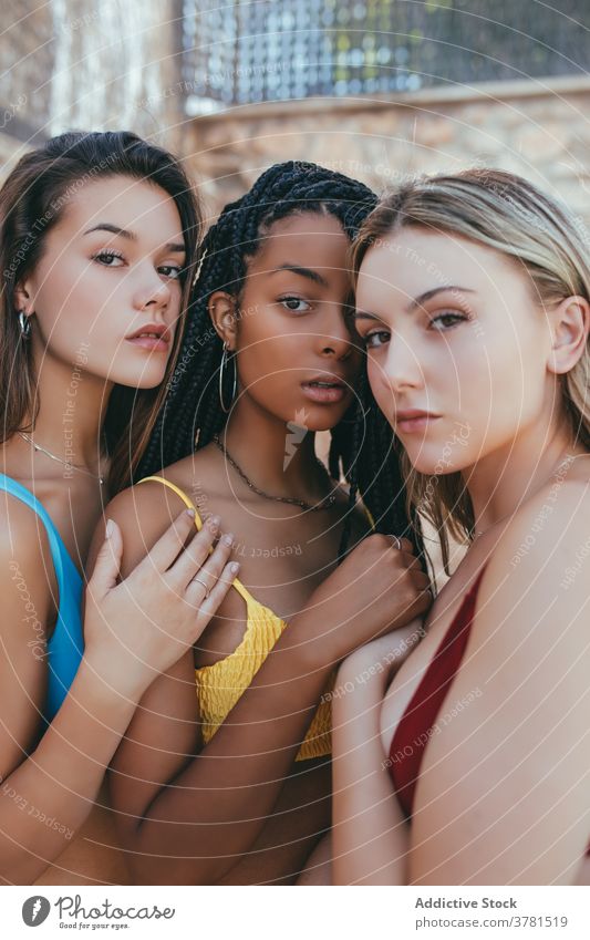Junge unterschiedliche Frauen im Bikini stehen zusammen Model Windstille schlank BH ruhig Freundschaft einzigartig Fotokamera rassenübergreifend multiethnisch
