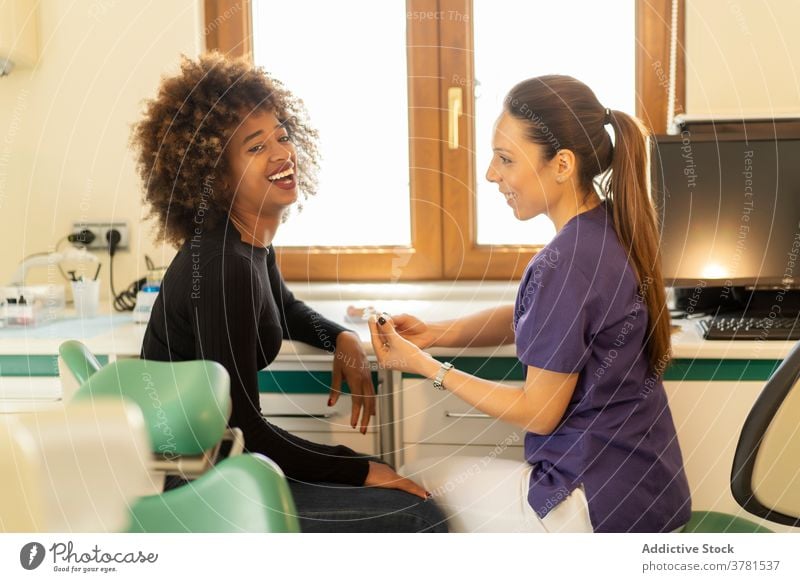 Schwarze Frau im Gespräch mit Zahnarzt geduldig Rezeption sprechend Zähne Implantat dental Klinik professionell Abfertigungsschalter Krankenpfleger Arzt
