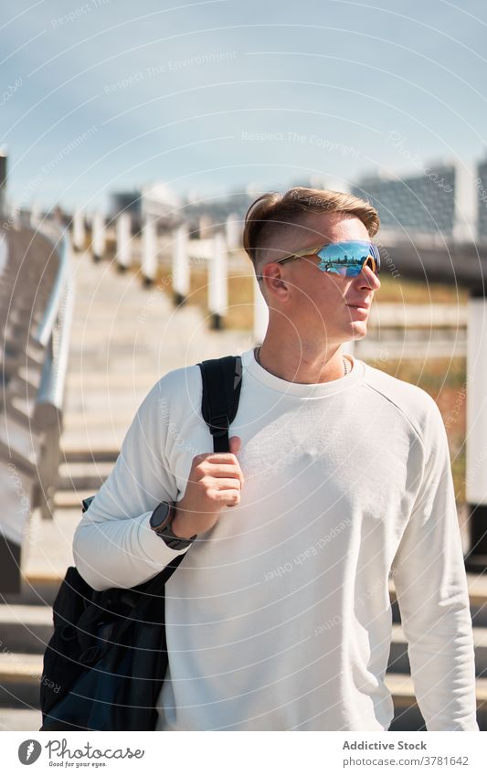 Stilvolle junger Mann mit Sonnenbrille zu Fuß auf Stadt Straße urban trendy Mode selbstbewusst modern Outfit Kleidungsstück männlich Zeitgenosse Großstadt