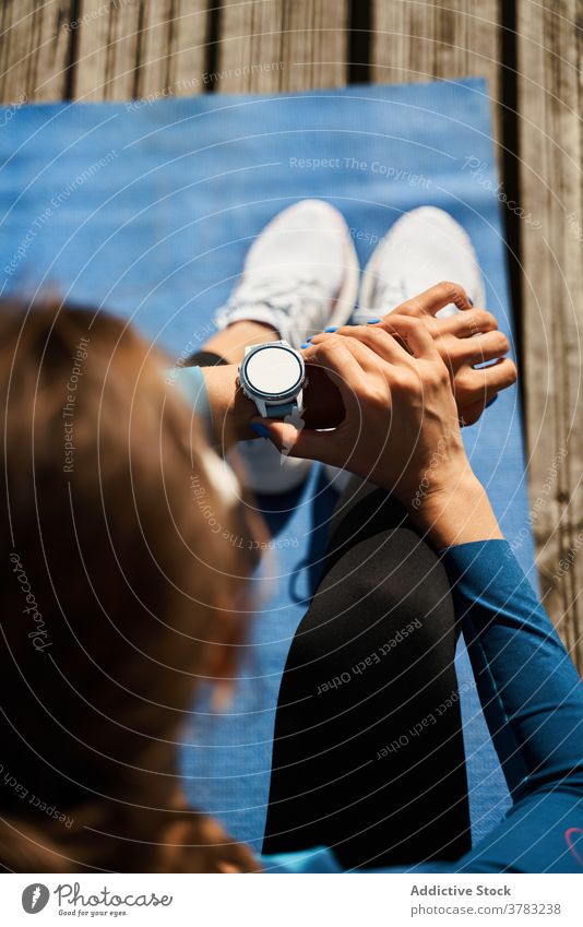 Sportliche Frau überprüft Fitness-Tracker während des Trainings sportlich intelligente Uhr prüfen Übung aktiv Puls Apparatur Gerät Lifestyle Ergebnis Herzschlag