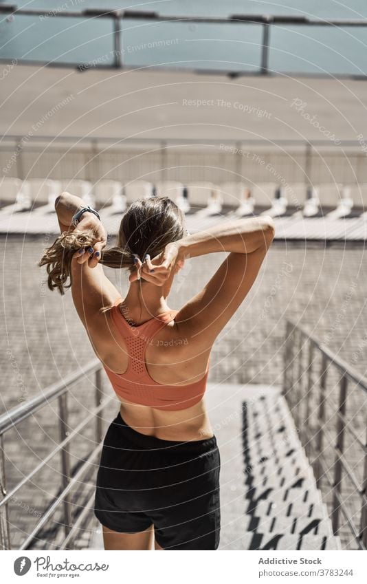 Sportliche Frau, die sich auf einer Böschung ausruht sportlich aktiv ruhen sich[Akk] entspannen Stauanlage Haarband Training passen schlank Fitness Übung