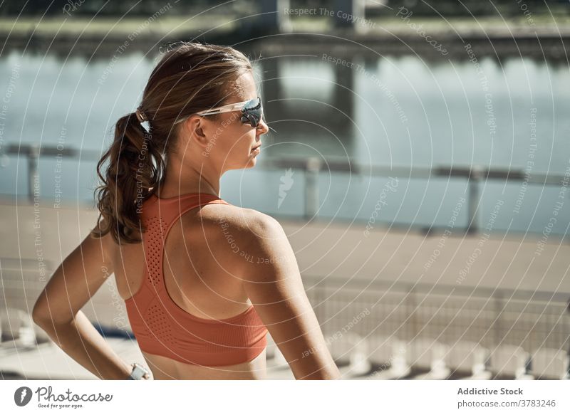 Sportliche Frau, die sich auf einer Böschung ausruht sportlich aktiv ruhen sich[Akk] entspannen Stauanlage Training passen bewundernd schlank Fitness Übung