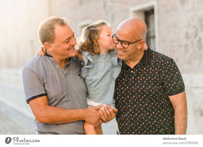 Erfreute LGBT-Familie auf der Straße lgbt Zusammensein Vater Männer schwul Paar Kind unterhalten Großstadt Durchgang Wochenende Sommer Spaziergang Glück Freude
