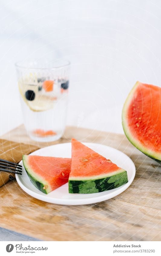 Scheiben von frischer Wassermelone auf Teller Spielfigur lecker Frucht dienen Tisch Erfrischung Küche hölzern Lebensmittel geschmackvoll Ernährung Vegetarier